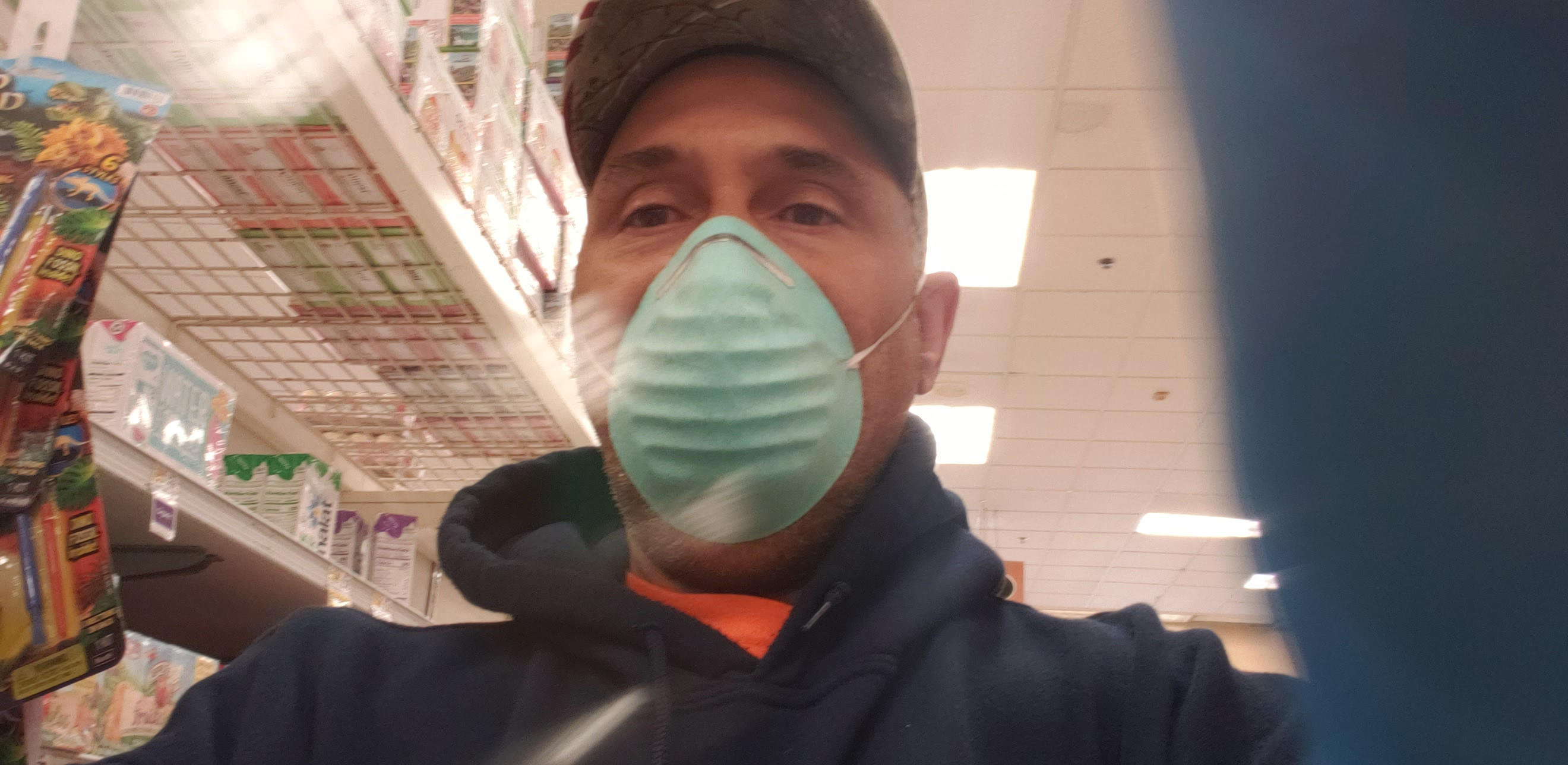 A man with a hat and a mask inside of a store.